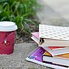 Ein Stapel Bücher und eine Papp-Kaffeebeche draußen