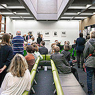 Sitzende und stehende Menschen im Ausstellungsraum