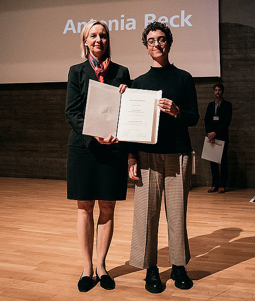 Das Bild zeigt die Universitätsfrauenbeauftragte und Antonia Reck bei der Übergabe der Urkunde.