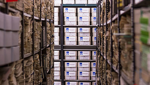 Blick durch die mit Archivalien gefüllten Regalreihen des Universitätsarchivs; Foto: Referat Kommunikation, M. Weich