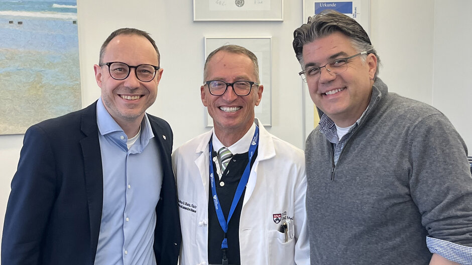 Drei Männer mittleren Alters lächeln in die Kamera. (öffnet Vergrößerung des Bildes)