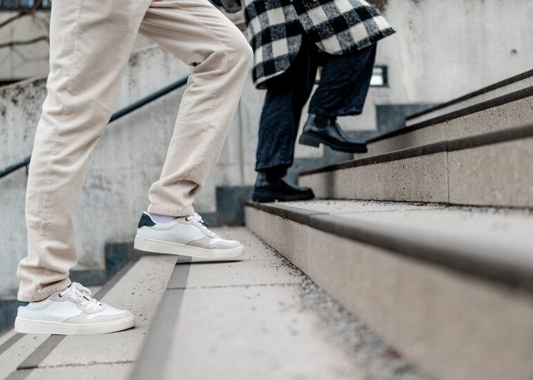 Zwei Personen gehen eine Treppe hinauf.