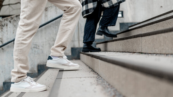 Zwei Personen gehen eine Treppe hinauf.