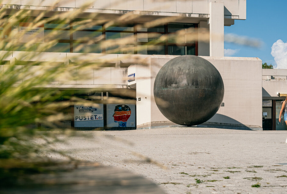 Studierende gehen über das Forum am Campus der Universität Regensburg. 