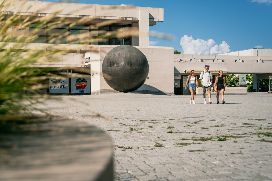 Studierende gehen über das Forum am Campus der Universität Regensburg. 