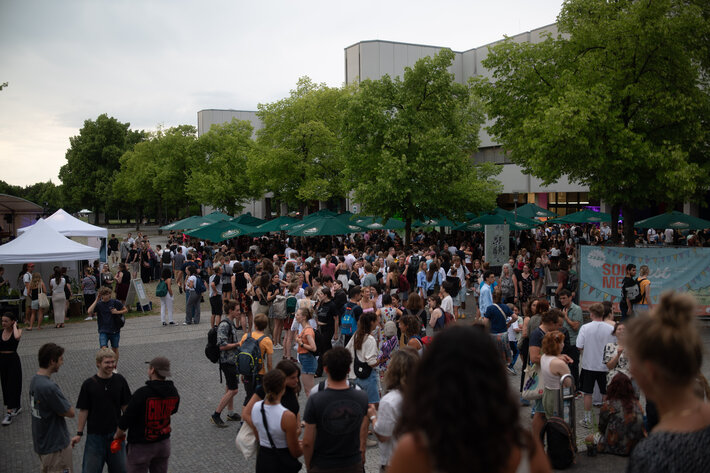 Sommerfestbesucherinnen und -besucher auf der Freifläche vor dem PT-Gebäude. (öffnet Vergrößerung des Bildes)