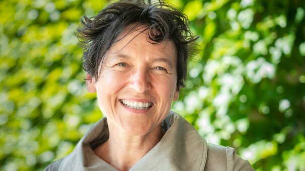 Smiling woman with short curly braun hair