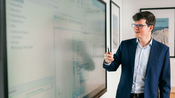 Ein Professor erklärt ein Schaubild auf einer elektronischen Tafel.