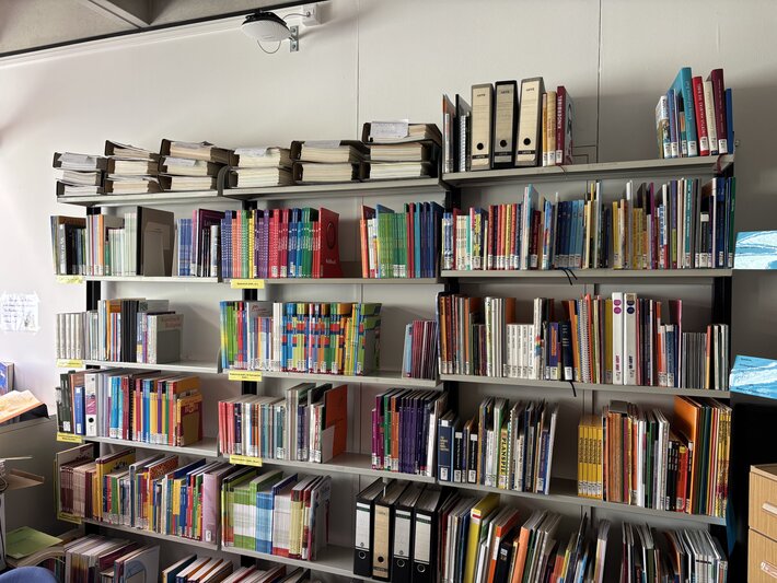 Mehrere Bücher sind auf 3 Regalen nebeneinander sortiert. (öffnet Vergrößerung des Bildes)