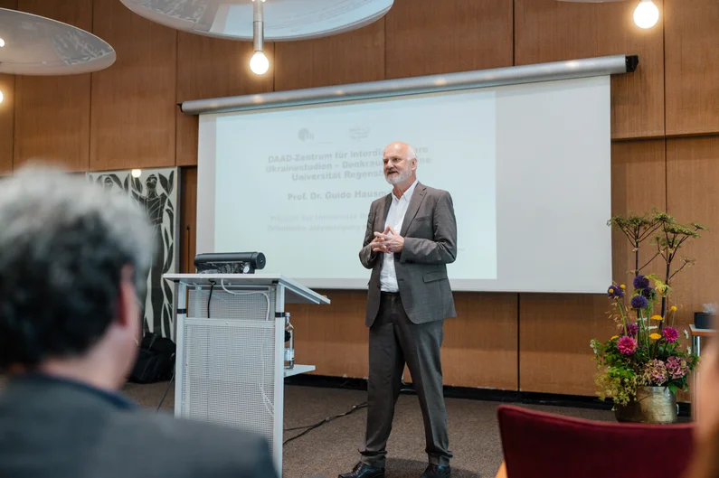 Ein Mann steht vor einer Powerpoint-Folie und hält einen Vortrag.  (öffnet Vergrößerung des Bildes)