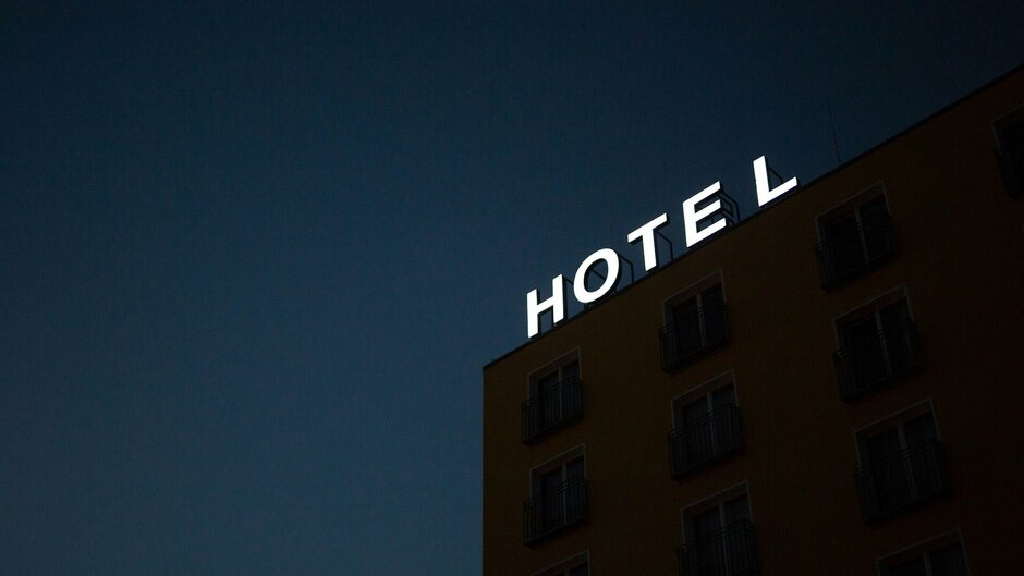 Illuminated sign "Hotel" in front of the night sky