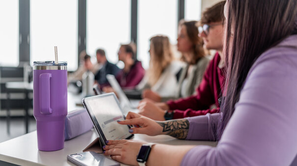 Studierende im Seminarraum mit Tablet und Smartphone