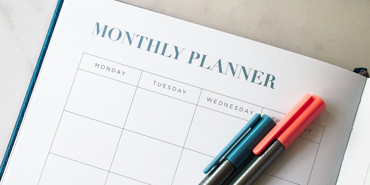 Zu sehen ist ein Terminplaner mit zwei Stiften