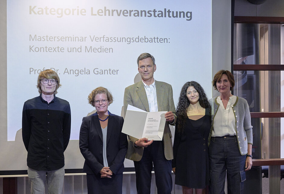 Fünf Personen stehend, zwei halten Urkunde