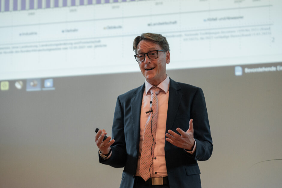 Ein Mann spricht mit ausdrucksstarkem Mienenspiel und Gestik.