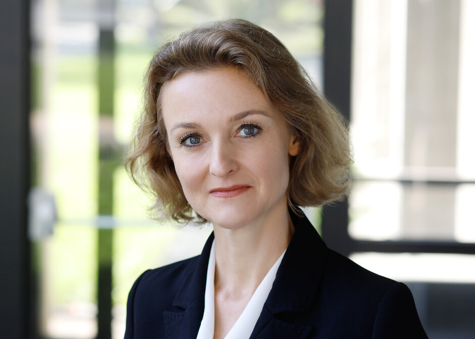 Eine Frau mit kinnlangem, blodem Haar schaut freundlich und zugewandt in die Kamera. Es handelt sich um eine Portrait-Aufnahme.