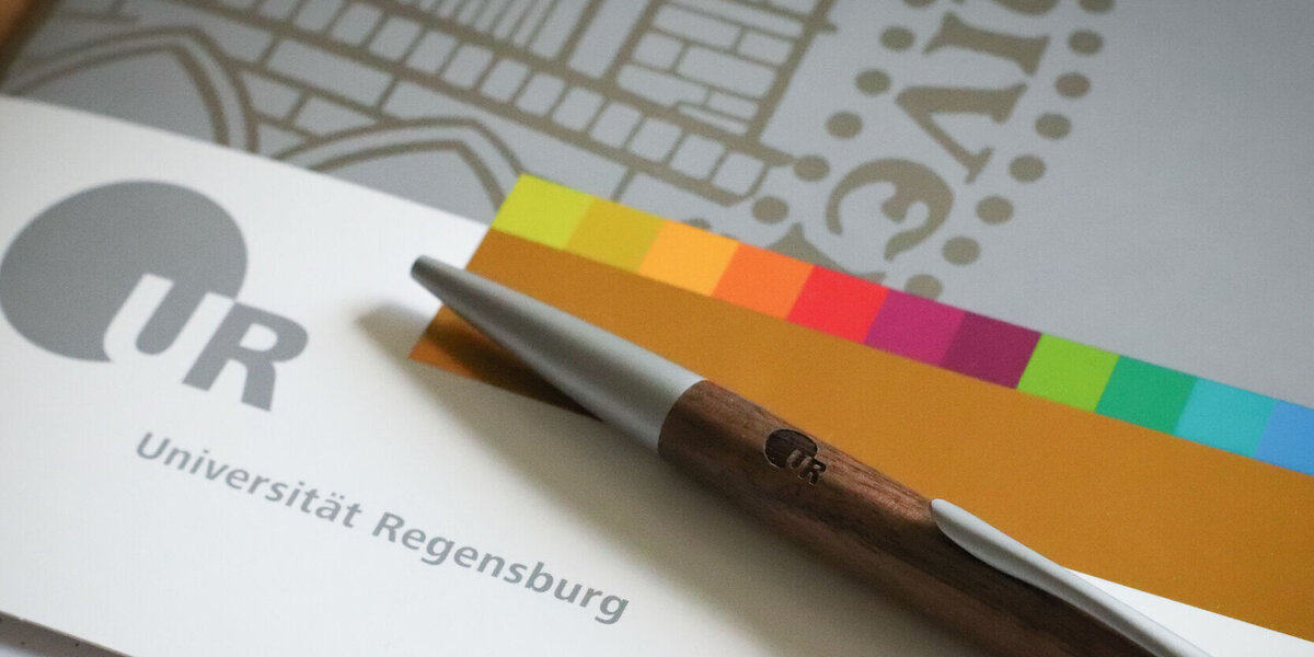 Mappe im Corporate Design der Uni Regensburg mit Kugelschreiber