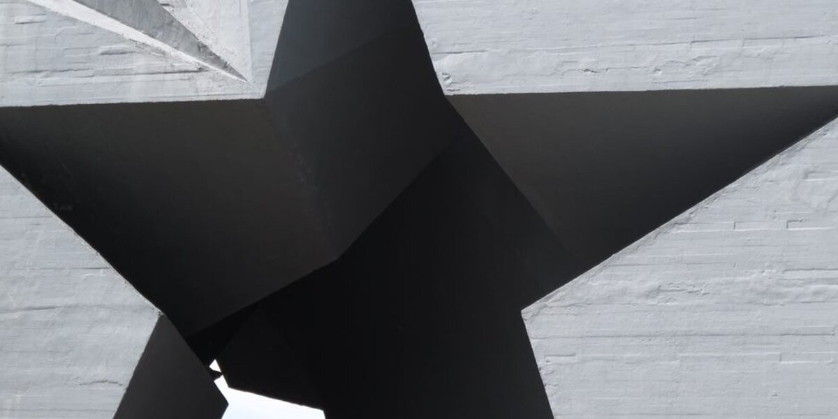 Eine sternförmige Aussparung in einer grau verputzten Mauer ist 