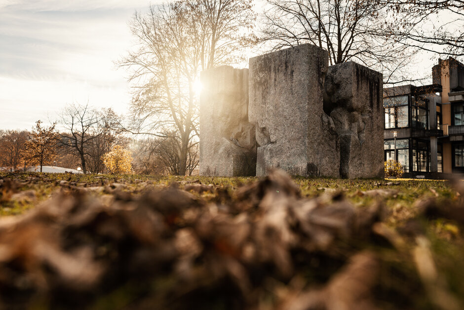 Herbstlaub vor dem Kunstwerk "Begehbarer Würfel"