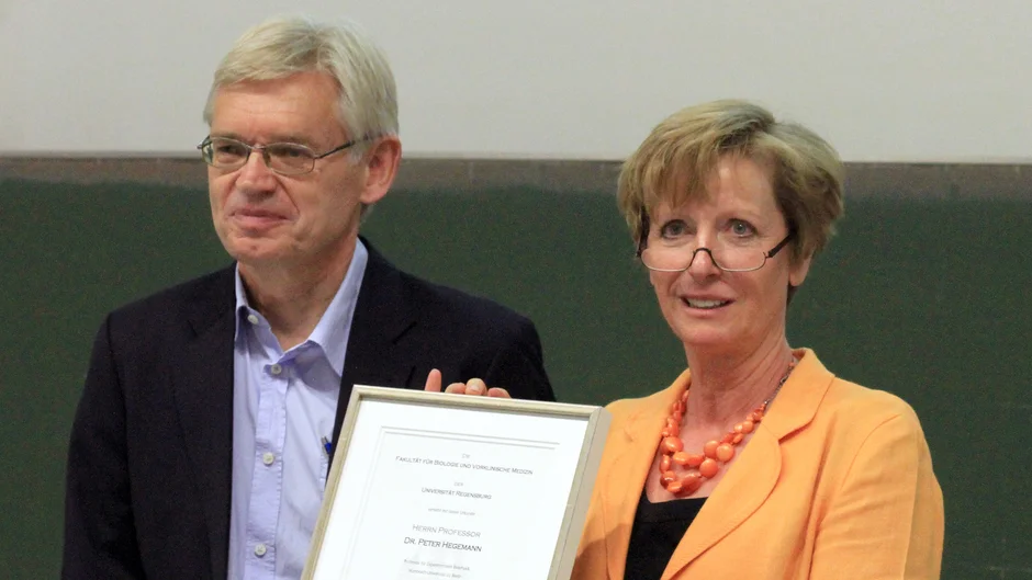 A man and a woman are standing, holding a certificate together. (opens enlarged image)
