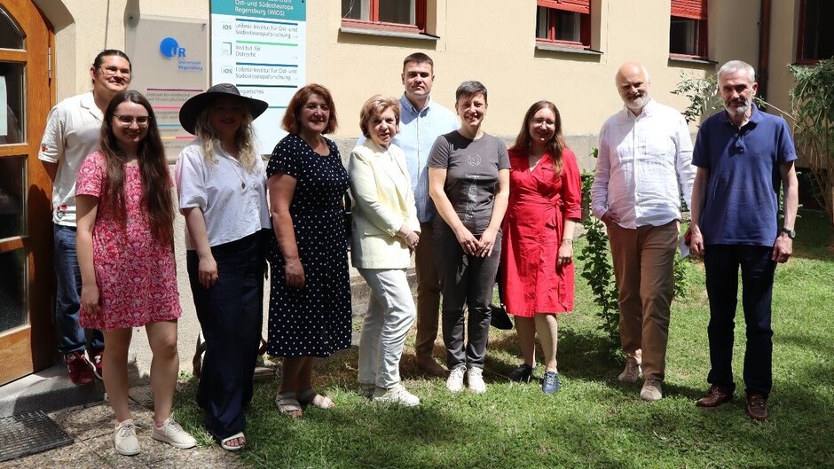Gruppenbild mit zehn Personen, stehend in Grünanlage.