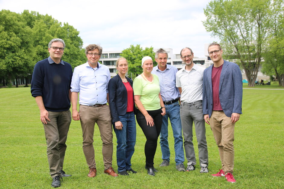 Sieben Personen stehen nebeneinander und schauen in die Kamera. (öffnet Vergrößerung des Bildes)