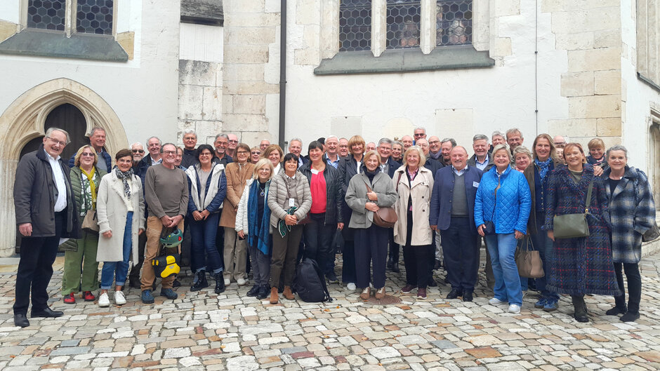 Eine große, fröhliche Gruppe von Männern und Frauen in herbstlicher Straßenkleidung. (öffnet Vergrößerung des Bildes)