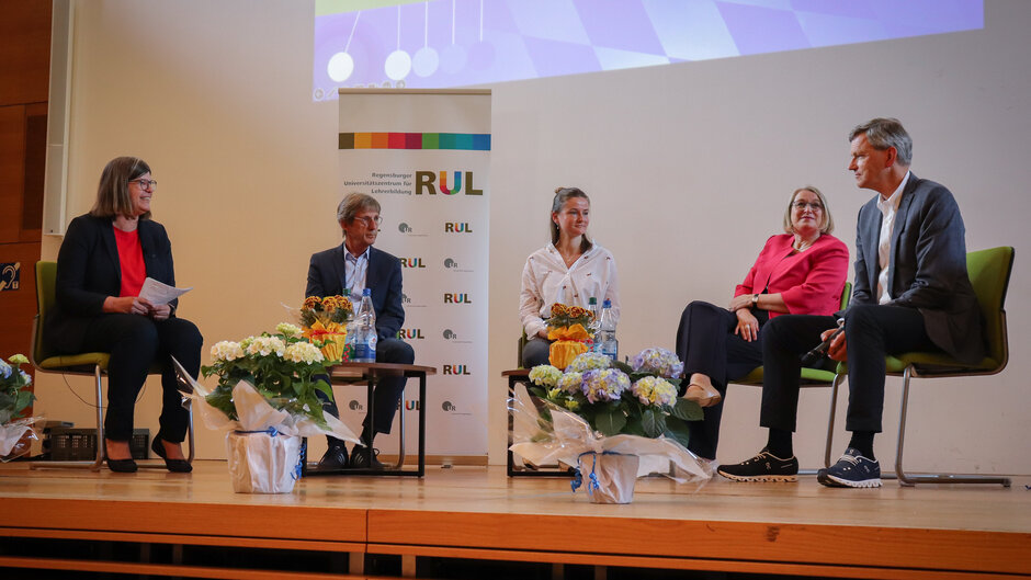 Fünf Personen sitzen auf einer Bühne und reden im Rahmen einer Podiumsdiskussion (öffnet Vergrößerung des Bildes)