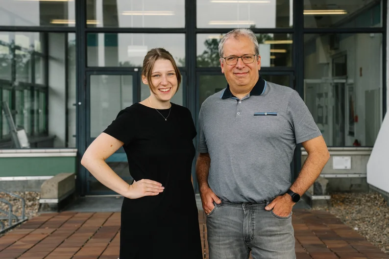 Eine Frau und ein Mann lächeln direkt in die Kamera.