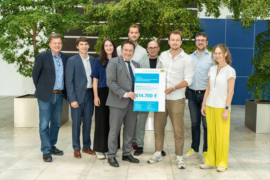 Bayerns Wirtschaftsstaatssekretär Tobias Gotthardt (4. v. l.) überreicht die Förderurkunde für das Forschungsprojekt REINSIST an die Projektpartner der Universität Regensburg sowie der Industrieunternehmen Krones, Scherdel Innotec und Integral-Scherdel.