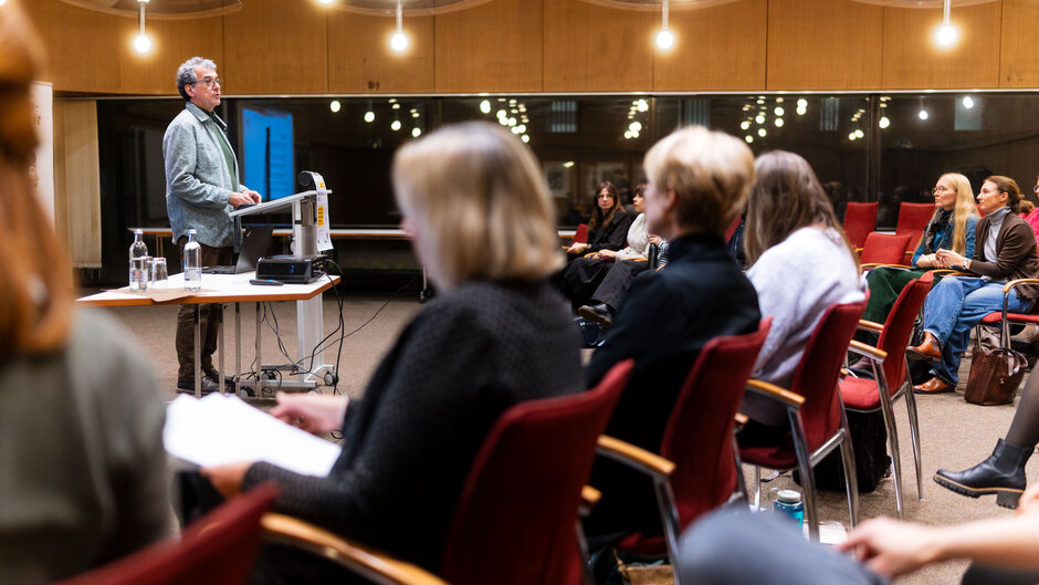 Mann spricht stehend an Rednerpult zu sitzendem Publikum. (öffnet Vergrößerung des Bildes)