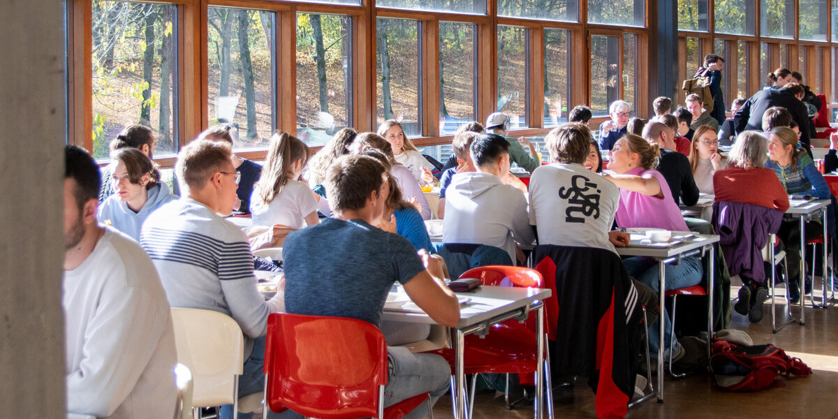 Studierende und Mitarbeitende der Universität beim Mittagessen in der Mensa.