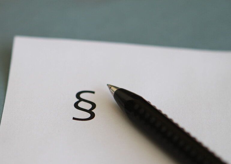 Paragraphenzeichen und Kugelschreiber