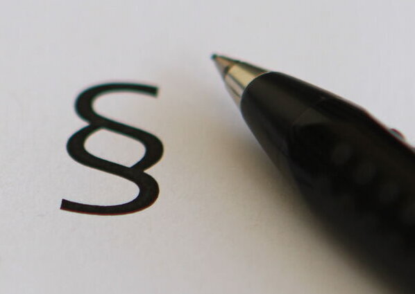 Paragraphenzeichen und Kugelschreiber