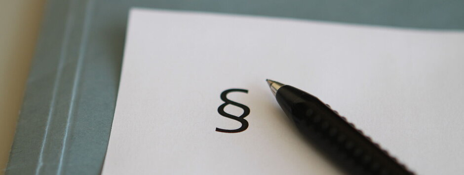 Paragraphenzeichen und Kugelschreiber