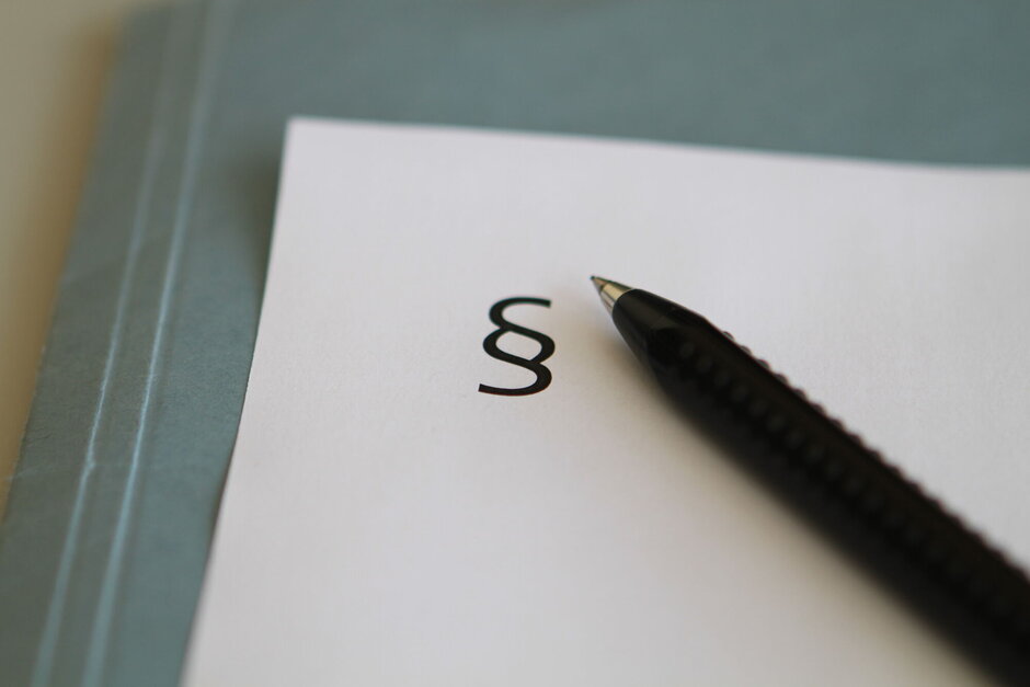 Paragraphenzeichen und Kugelschreiber