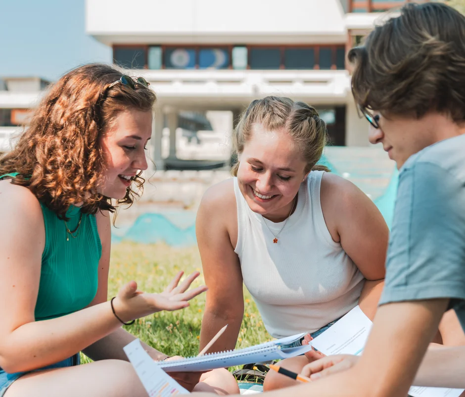 Studierende sitzen zusammen am Campus der Universität Regensburg.