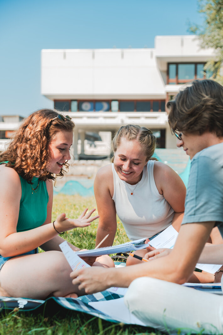 Studierende sitzen zusammen am Campus der Universität Regensburg. (opens enlarged image)
