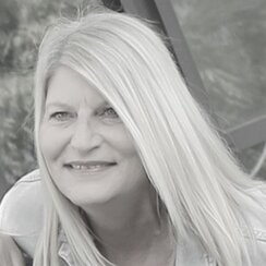 Das Foto zeigt ein Schwarz-Weiß-Porträt der Lehrstuhlsekretärin Petra Bettinger.