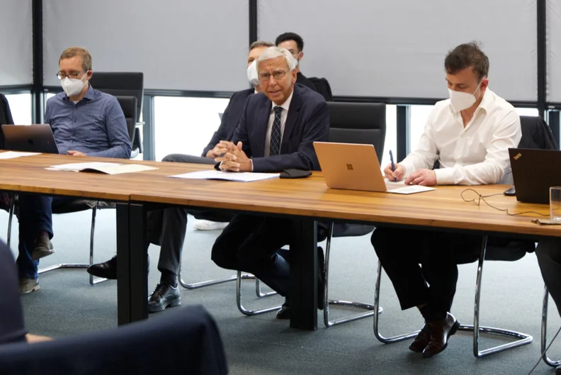 Mehrere Männer sitzen in einem Konferenzsaal an einem langen Tisch. Zum Teil tragen sie FFP2-Gesichtsmasken. (öffnet Vergrößerung des Bildes)