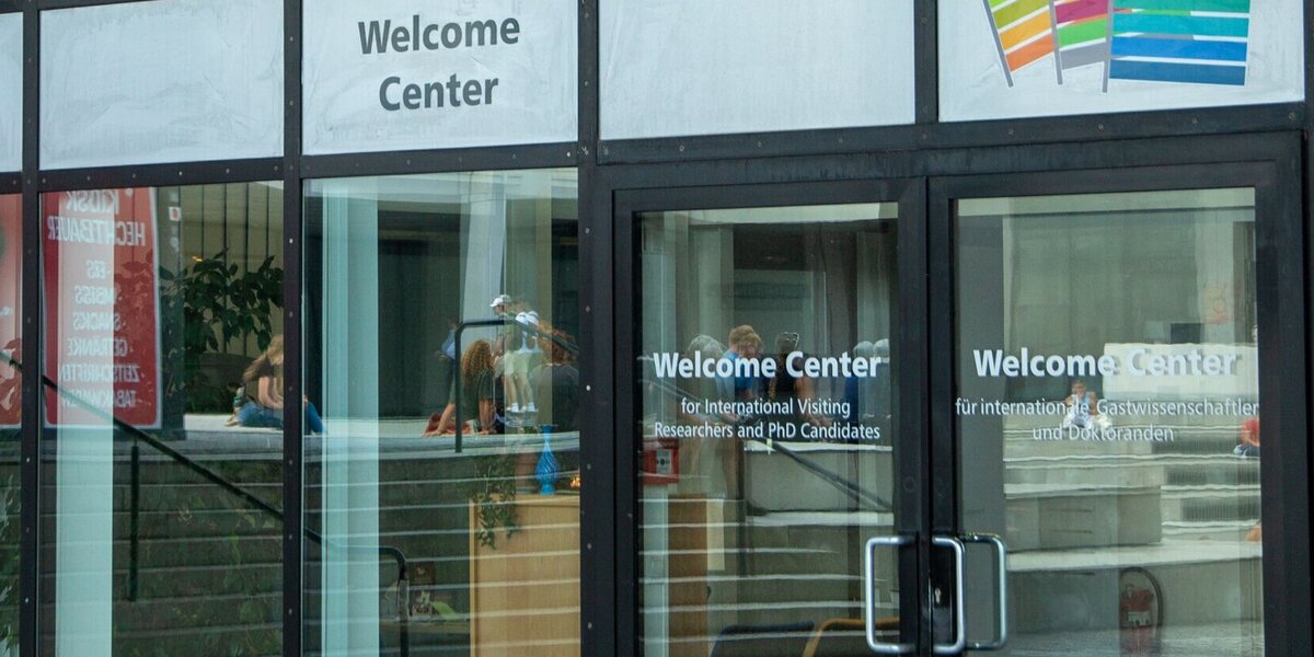 Gebäude mit großen Glasfenstern und Aufschrift "Welcome Center"