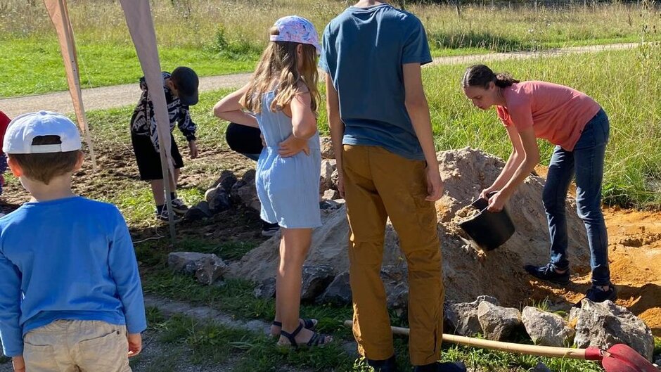 Children fill sand into the sandarium