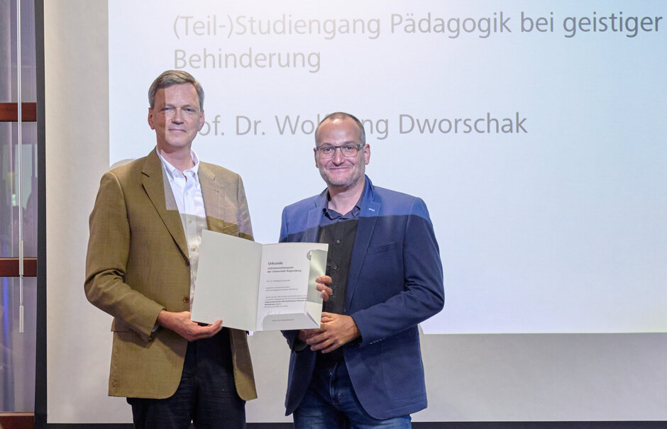 Zwei Männer stehend, gemeinsam Urkunde haltend