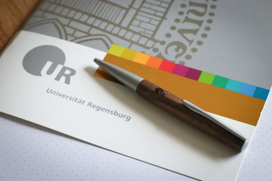 Mappe im Corporate Design der Uni Regensburg mit Kugelschreiber