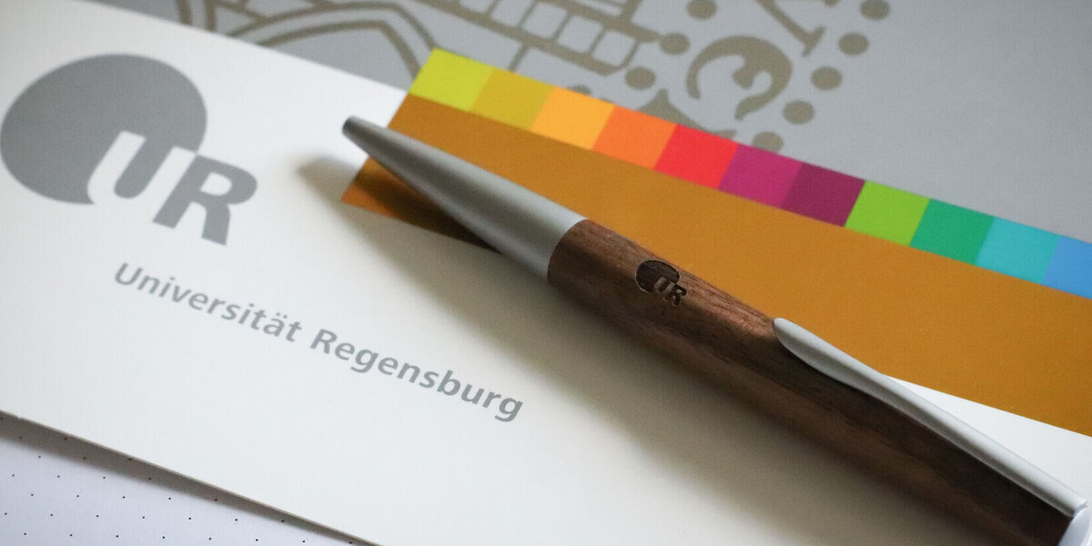 Mappe im Corporate Design der Uni Regensburg mit Kugelschreiber