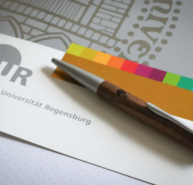 Mappe im Corporate Design der Uni Regensburg mit Kugelschreiber