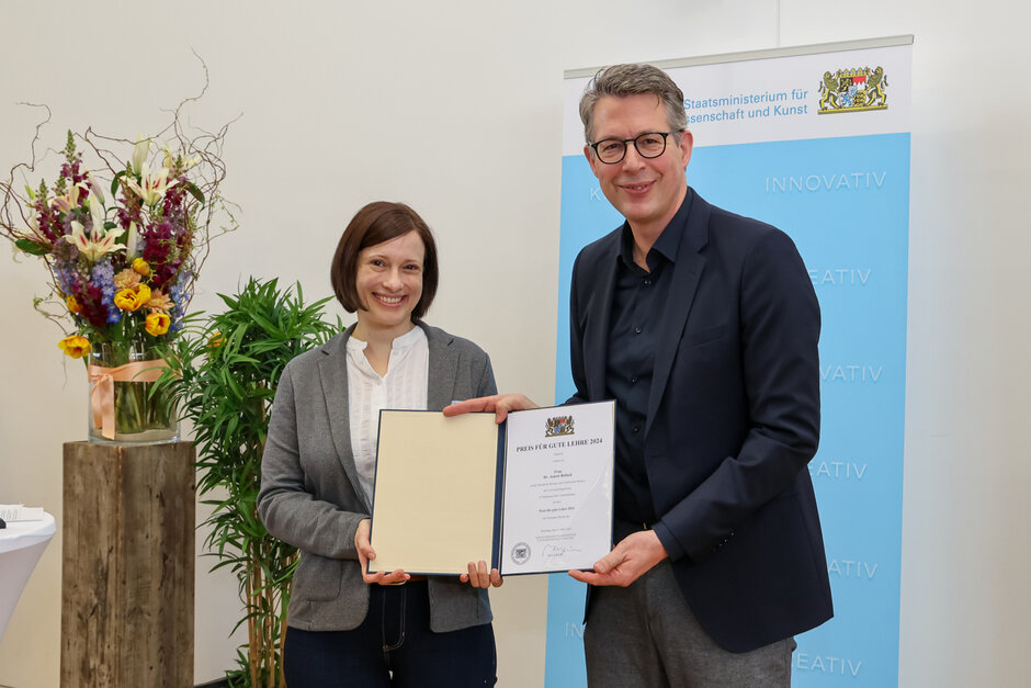 Eine Frau und ein Mann haltend lächelnd gemeinsam eine Urkunde in Richtung Kamera. (öffnet Vergrößerung des Bildes)