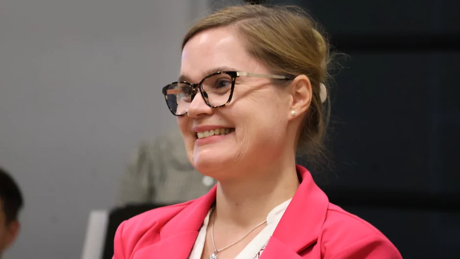 Frau mit Brille und hochgesteckten Haaren, lächelnd (öffnet Vergrößerung des Bildes)