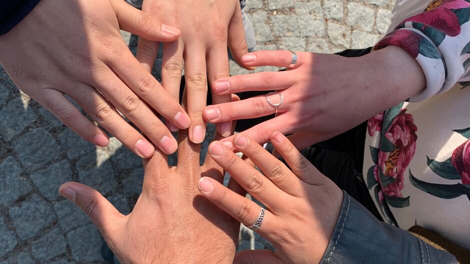 Fünf Hände liegen übereinander