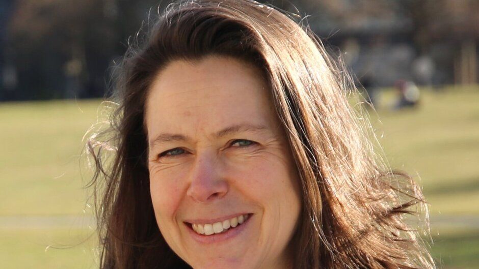 Freundlich lächelnde Frau mit brünetten Haaren schaut in die Kamera